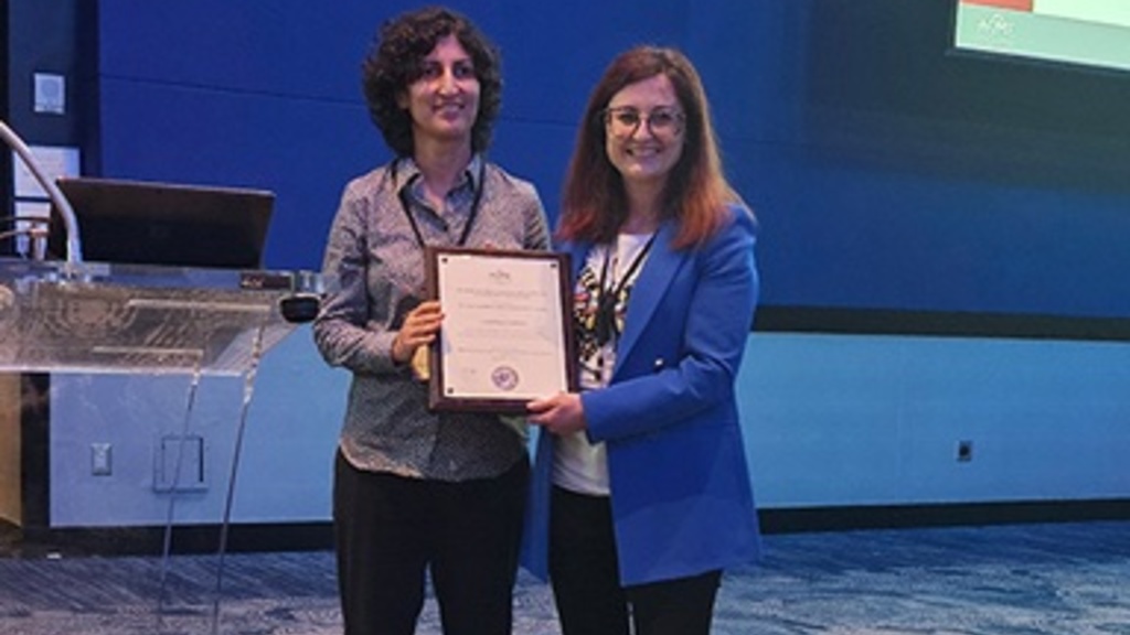 Two people holding an award